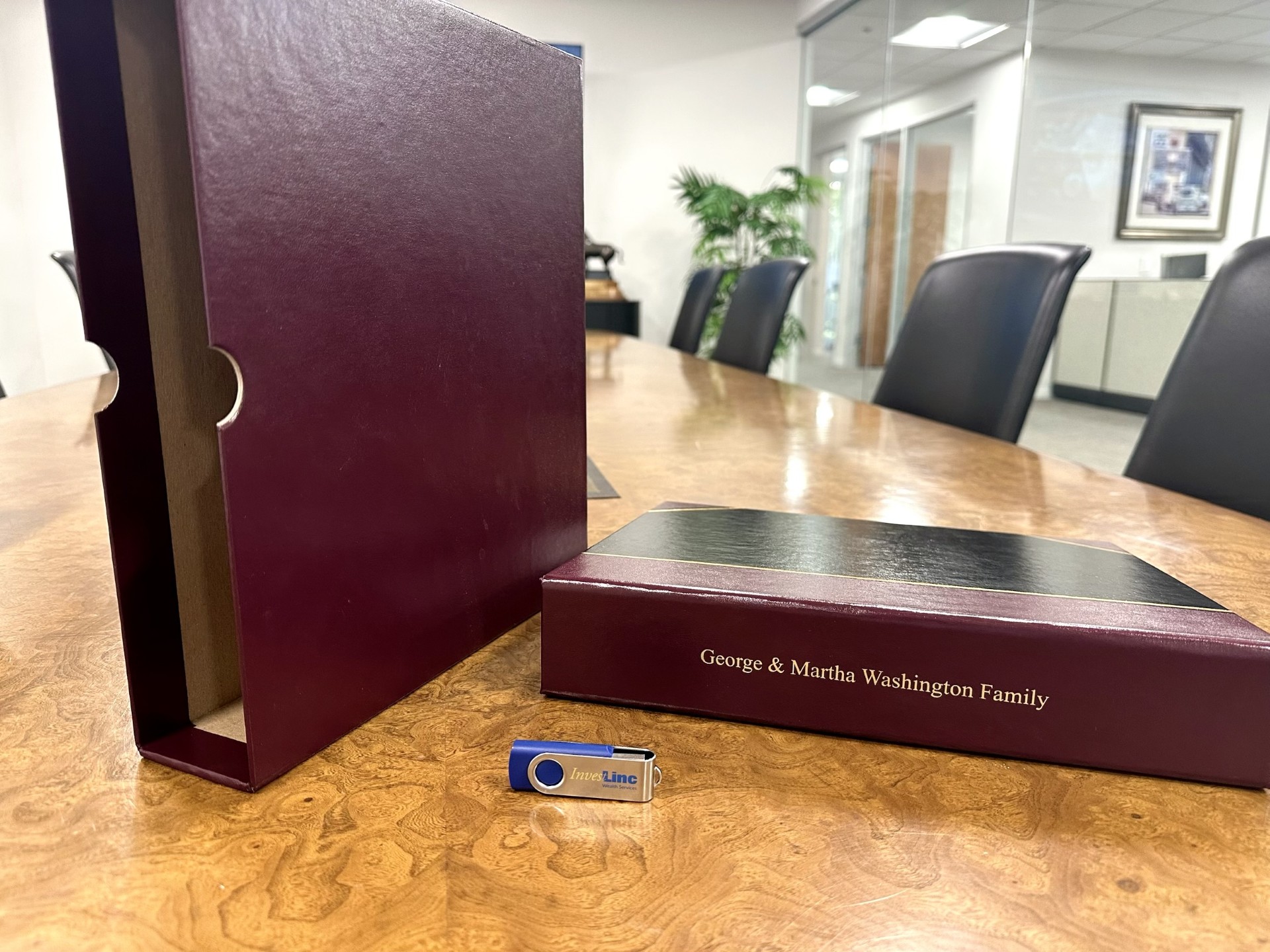 The Compendium binder, slipcase, and InvestLinc thumb drive on the conference table